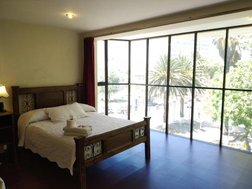 科恰班巴Hotel Maison Fiori Prado的一间卧室设有一张床和一个大窗户