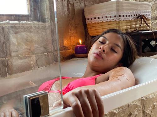 基多Treehouse Gastro Hotel的躺在浴缸中的女人