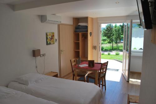 圣让萨韦讷莱斯维涅住宿加早餐旅馆的卧室配有两张床、一张桌子和一张桌子以及椅子。