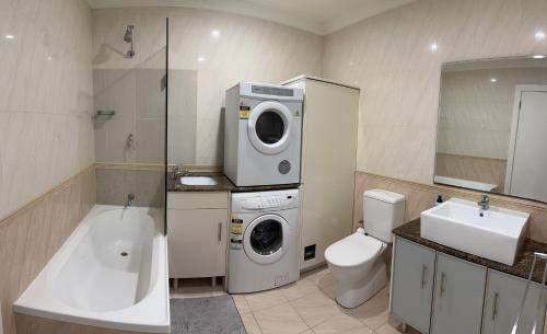 阿德莱德Bundled Bliss 2 bedroom Condo in Adelaide CBD的一间带洗衣机和卫生间的浴室