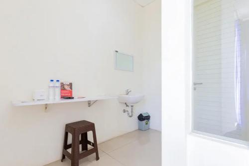 KendungRedDoorz @ Bukit Palma Surabaya的白色的浴室设有水槽和凳子