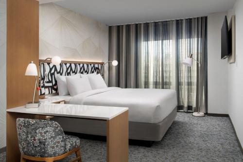 皇后区SpringHill Suites by Marriott New York Queens的配有一张床和一张书桌的酒店客房
