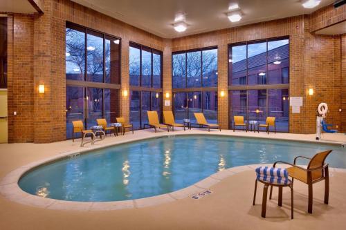 奥格登奥格登万怡酒店的酒店大堂的游泳池,配有桌椅