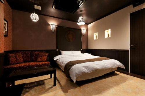 KumoharaHOTEL GEN 福知山店的一间卧室配有一张床和一张沙发