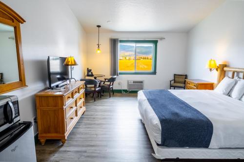 维克托坦顿山谷汽车旅馆的一间卧室配有一张床、一台电视和一张桌子