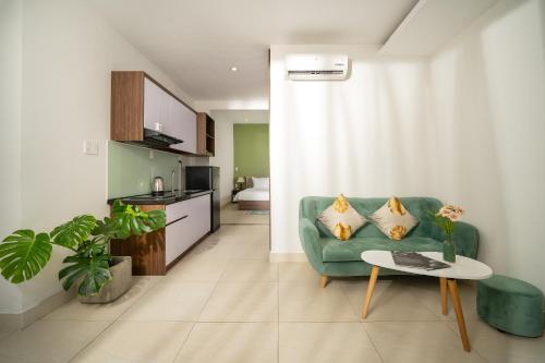 岘港Tashi Park View Hotel & Apartment的客厅配有绿色沙发和桌子