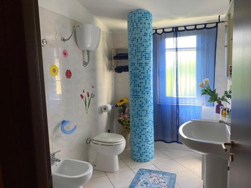 伊索拉迪卡波里祖托Residenza il sole isola Capo Rizzuto的一间带卫生间和蓝色柱子的浴室