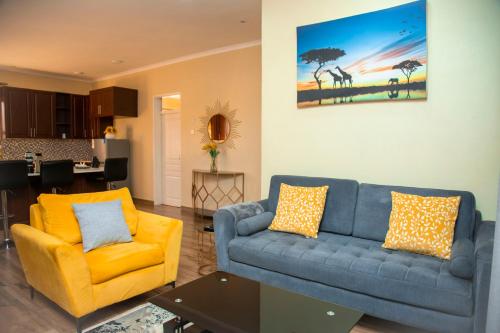 利隆圭Acacia Stay的客厅配有蓝色的沙发和黄色的椅子