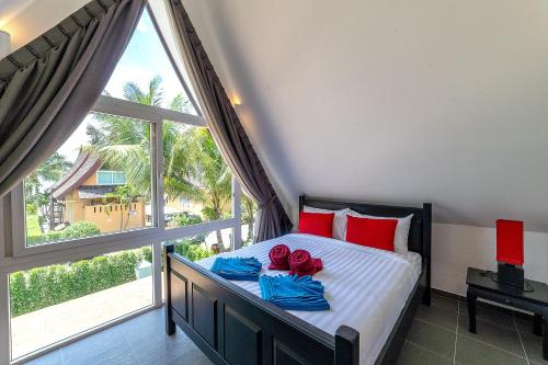 象岛Villa of Siam的一间卧室配有一张带红色枕头的床和大窗户