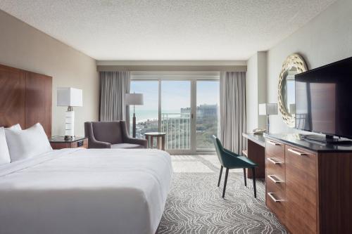 默特尔比奇Marriott Myrtle Beach Resort & Spa at Grande Dunes的配有一张床和一台平面电视的酒店客房