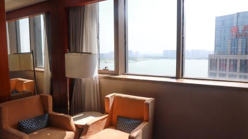 苏州苏州福朋喜来登酒店的酒店客房设有两把椅子和一扇窗户。