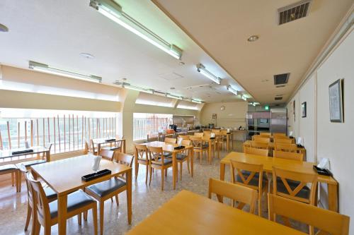 和歌山和歌山县第一核电站富士酒店的一间设有木桌和椅子的餐厅