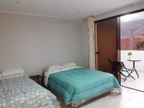 卢那欢纳El Valle Lunahuaná的一间卧室配有一张床、一张桌子和一个窗户。