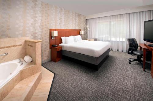 拉夫金拉夫金万怡酒店的酒店客房设有床、浴缸和水槽