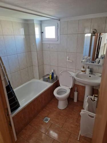 尼亚·蒙达尼亚Πλήρως εξοπλισμένο διαμέρισμα.的带浴缸、卫生间和盥洗盆的浴室