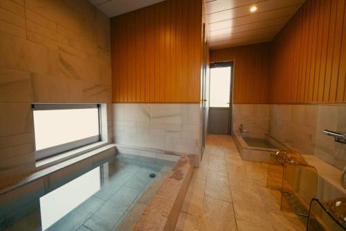 富士河口湖Private Villa ietona的一间带游泳池和浴缸的大浴室