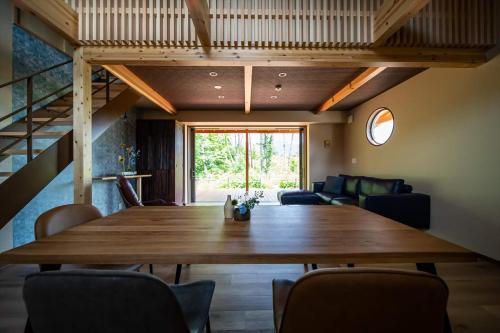 富士河口湖Private Villa ietona的一间带木桌和椅子的用餐室