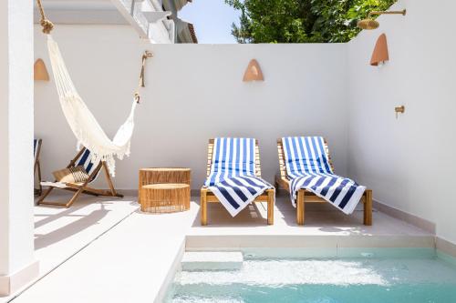 EsteponaEsencia Marbella Casas Boutique的庭院设有两把椅子和吊床,庭院内设有游泳池。