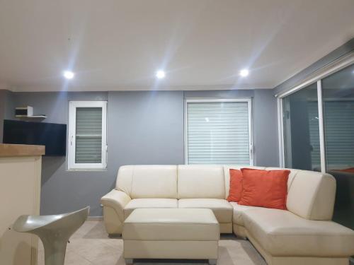 艾瓦勒克Modern Studio Apartment with Garden的客厅配有带红色枕头的白色沙发