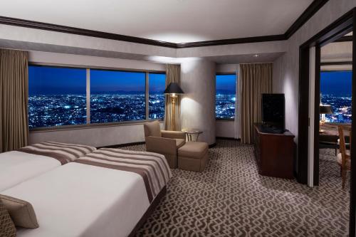 横滨横滨皇家花园酒店的酒店客房设有一张大床和一张书桌。