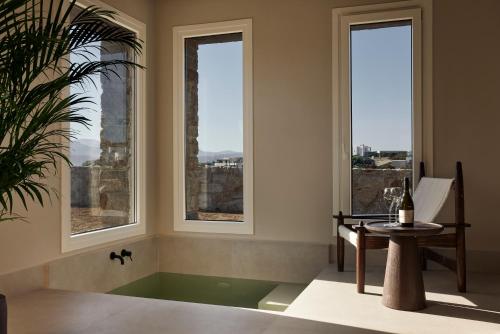 斯泰里达Naxian Rhapsody的客房设有窗户和一个带桌子的浴缸。
