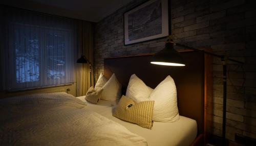 埃伦德格鲁恩塔纳曼德霍尔酒店的一间卧室配有一张带白色枕头和灯的床。