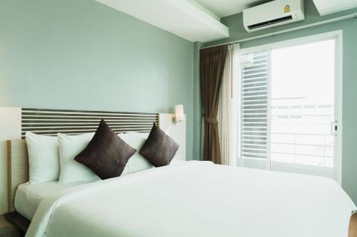 坤敬绿色度假酒店 的卧室配有白色的床和窗户。