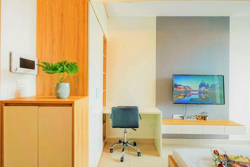 胡志明市INNSiDE Apartment - RiverGate Residence, Free GYM and POOL的一间带椅子和墙上电视的房间