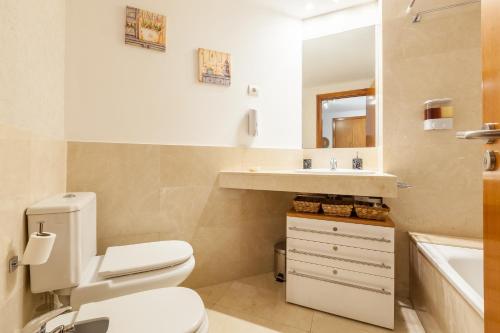 克尤伯厄拉斯Cubelles mar的一间带卫生间、水槽和镜子的浴室