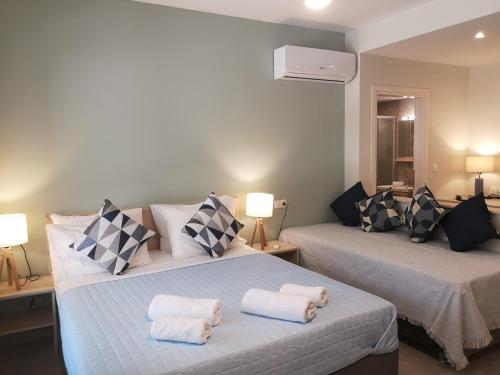 卡法斯Iris Studios Chios的一间卧室配有两张带毛巾的床