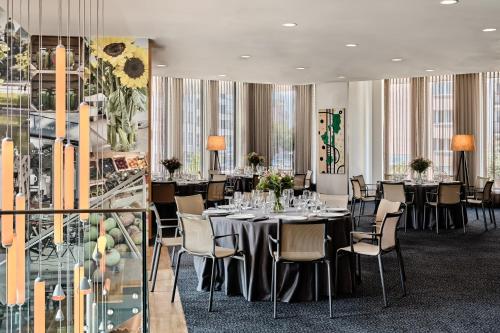 华沙假日酒店 - 华沙​​市中心的用餐室设有桌椅和窗户。