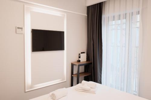 伊斯坦布尔Persona Hotel Galata的一间带镜子的卧室和一张带电视的床
