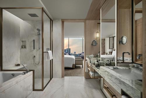新加坡Marina Bay Sands的一间带浴缸和水槽的浴室以及一间客房。