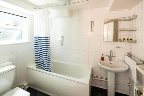 克劳奇河畔伯纳姆The Royal Burnham Yacht Club的一间带水槽、浴缸和卫生间的浴室