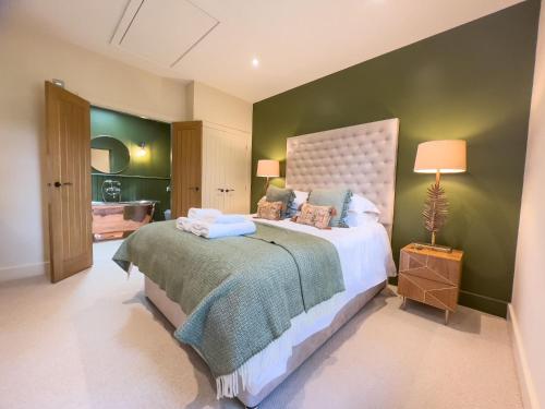 布兰普顿Waters Edge, Talkin Tarn, nr Brampton的一间卧室设有一张大床和绿色的墙壁