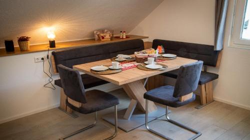 施卢赫湖Ferienwohnung Mayer的一张木桌,配有两把椅子和一张桌子,上面有食物