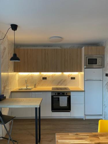 乌苏尔维尔Cozy apartment 6' from San Sebastian + Parking的一间厨房,配有白色家电和一张桌子