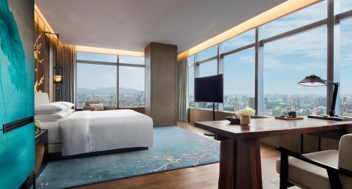 杭州杭州柏悦酒店（天际下午茶，网红餐厅酒吧）的酒店客房设有一张床、一张书桌和窗户。