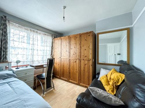 伦敦Spacious Double Bedroom in Shooters Hill的一间带沙发、书桌和镜子的卧室