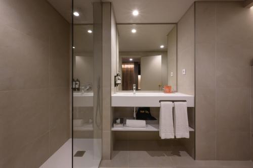科英布拉Hotel Coimbra Aeminium, Affiliated by Meliá的一间带水槽和镜子的浴室