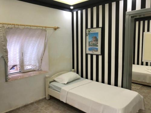 EmecikHALİSE APART的一间小卧室,配有一张床和条纹墙