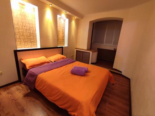 巴甫洛达尔Уютная трёхкомнатная квартира的一间卧室配有一张带橙色毯子的大床