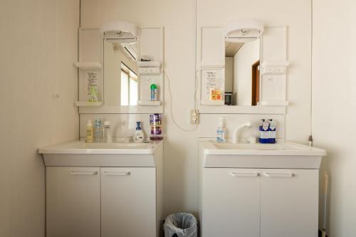尾道市Bed&Cafe Onzo オンゾー的浴室设有2个水槽和镜子