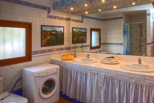 Tejina de IsoraViVaTenerife - Retreat in nature, SPA and wellness的一间带两个盥洗盆和洗衣机的浴室