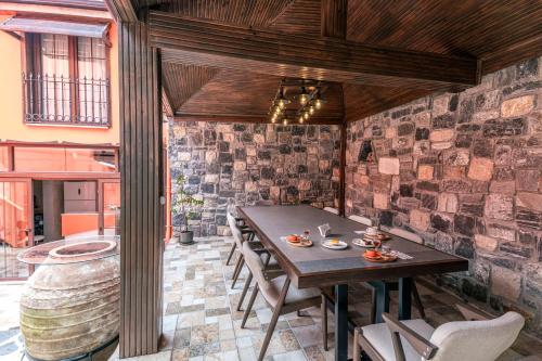 伯萨CASA MİSYA的一间设有桌椅和砖墙的用餐室