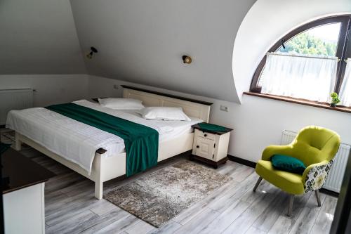 普特纳Casa Românească的卧室配有床、椅子和窗户。