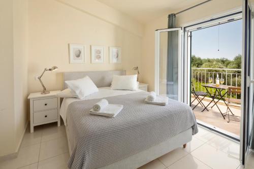 阿尔米罗斯海滩Skales Villas的一间白色卧室,配有床和阳台