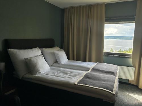 威廉敏娜威廉敏娜酒店的一张位于带大窗户的房间内的床铺