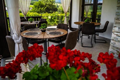 普特纳Casa Românească的庭院配有桌椅和红色鲜花