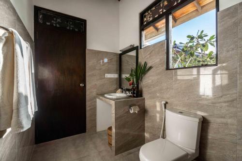 坦加拉安纳塔亚海滩酒店的一间带卫生间、水槽和镜子的浴室